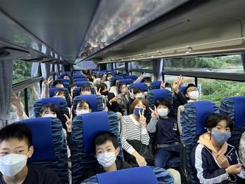 バスに乗って学校を出発する児童