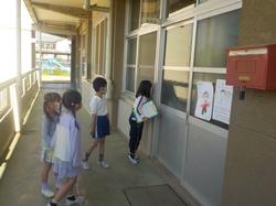事務室の先生に声をかける2年生