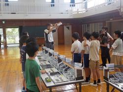 流れ作業の工程の説明を受ける5年生