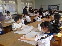 袖をたくし上げ、絵の具を使く準備をする1年生