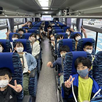 バスに乗って学校に向かう児童
