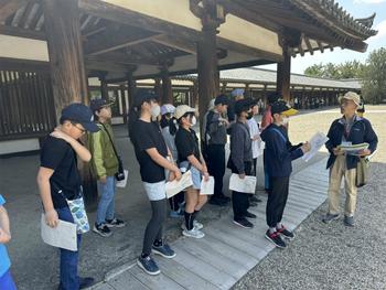 法隆寺でガイドの話を聞く児童(1)