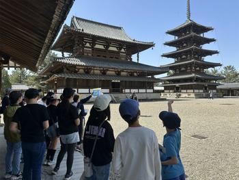 法隆寺でガイドの話を聞く児童(2)