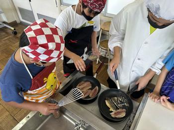 魚を焼く児童(2)