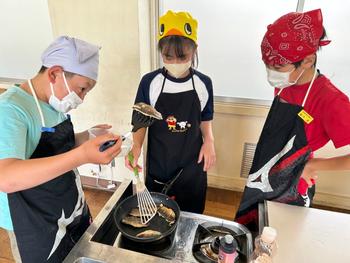 魚を焼く児童