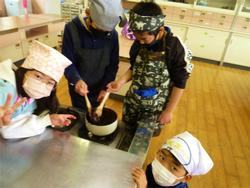 黒豆をつぶしながら煮詰めている