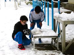 運動場で雪遊びをする三樹っ子たち
