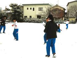 運動場で雪遊びをする三樹っ子たち
