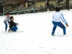 運動場で雪遊びをする三樹っ子たち