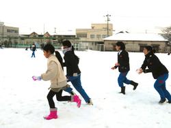 運動場で雪遊びをする三樹っ子たち
