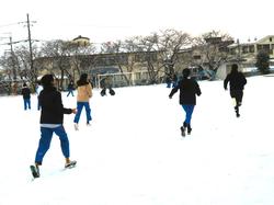 運動場で雪遊びをする三樹っ子たち