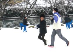 運動場で雪遊びをする三樹っ子たち