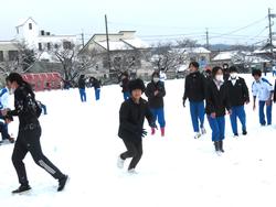 運動場で雪遊びをする三樹っ子たち