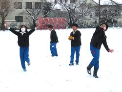 運動場で雪遊びをする三樹っ子たち