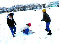 運動場で雪遊びをする三樹っ子たち