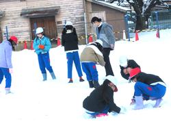 運動場で雪遊びをする三樹っ子たち