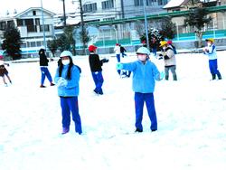 運動場で雪遊びをする三樹っ子たち