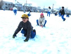 運動場で雪遊びをする三樹っ子たち