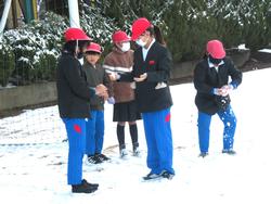 運動場で雪遊びをする三樹っ子たち
