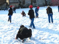 運動場で雪遊びをする三樹っ子たち
