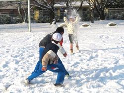 運動場で雪遊びをする三樹っ子たち
