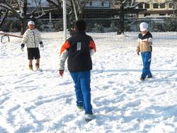 運動場で雪遊びをする三樹っ子たち