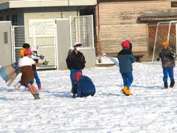 運動場で雪遊びをする三樹っ子たち