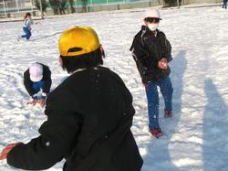 運動場で雪遊びをする三樹っ子たち