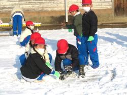 運動場で雪遊びをする三樹っ子たち
