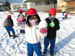運動場で雪遊びをする三樹っ子たち