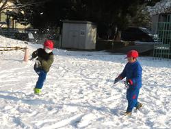 運動場で雪遊びをする三樹っ子たち