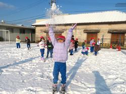 運動場で雪遊びをする三樹っ子たち