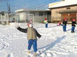 運動場で雪遊びをする三樹っ子たち