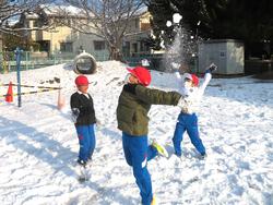 運動場で雪遊びをする三樹っ子たち