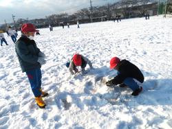 運動場で雪遊びをする三樹っ子たち