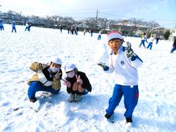 運動場で雪遊びをする三樹っ子たち