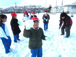 運動場で雪遊びをする三樹っ子たち