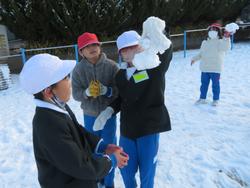 運動場で雪遊びをする三樹っ子たち