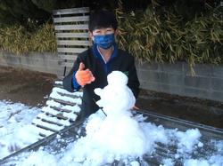 運動場で雪遊びをする三樹っ子たち