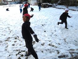 運動場で雪遊びをする三樹っ子たち