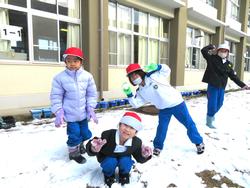 運動場で雪遊びをする三樹っ子たち