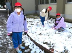 運動場で雪遊びをする三樹っ子たち