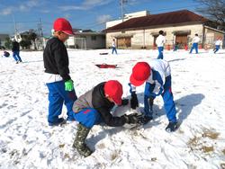 運動場で雪遊びを楽しむ三樹っ子たち