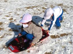 運動場で雪遊びを楽しむ三樹っ子たち