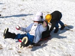 運動場で雪遊びを楽しむ三樹っ子たち