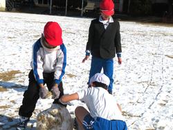 運動場で雪遊びを楽しむ三樹っ子たち