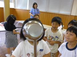 お玉に顔を入れる子ども