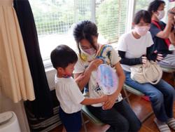 うちわを渡す子ども