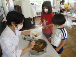 カレーをよそってもらう園児