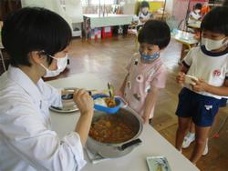 カレーをよそってもらう園児